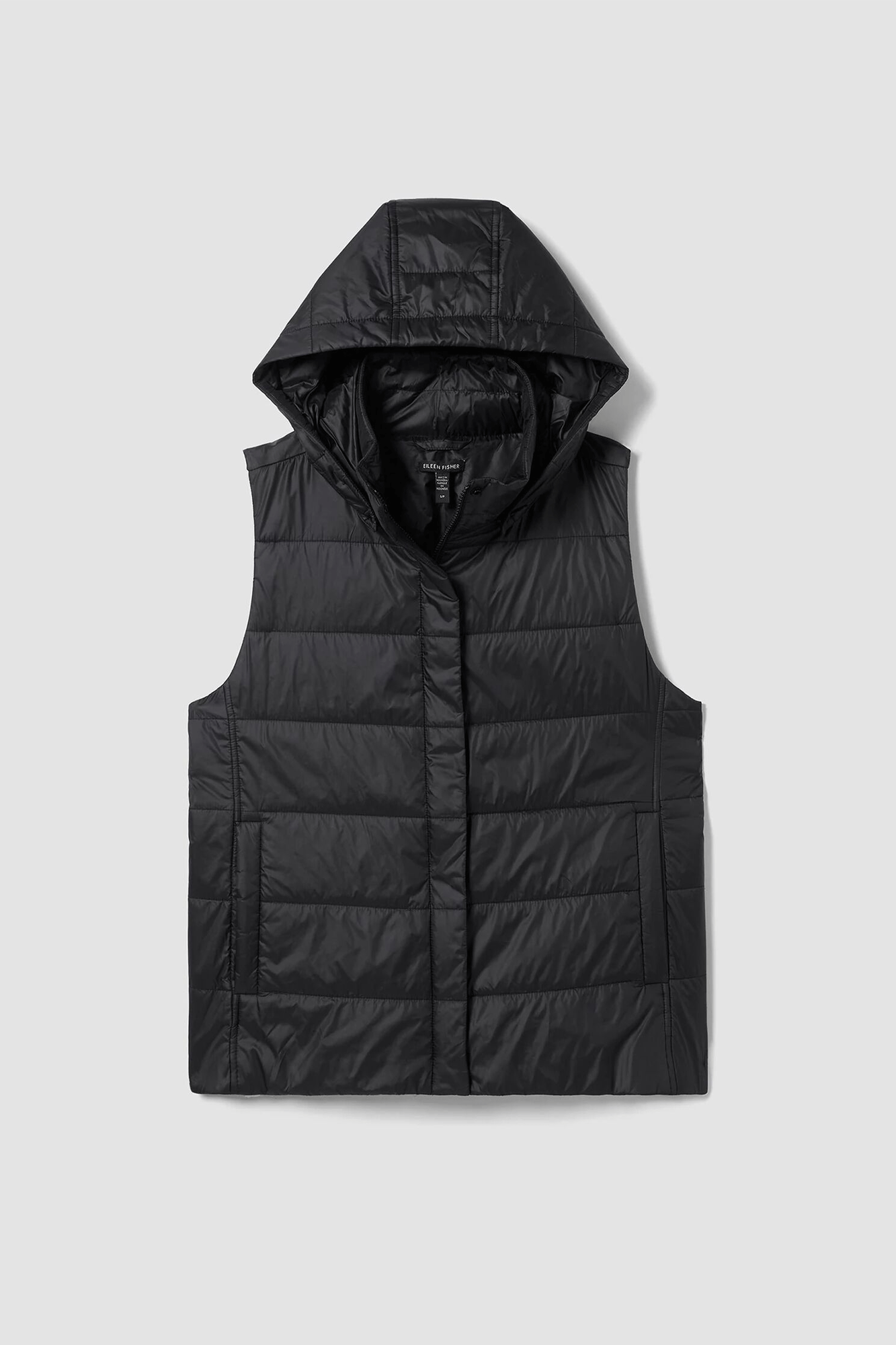 Stay warm this winter with the Padded Vest with Removable Hood from Eileen Fisher! Made from recycled nylon material that traps heat efficiently and is eco-friendly, this stylish seasonal staple features a secure front zip closure and a detachable hood for added comfort.