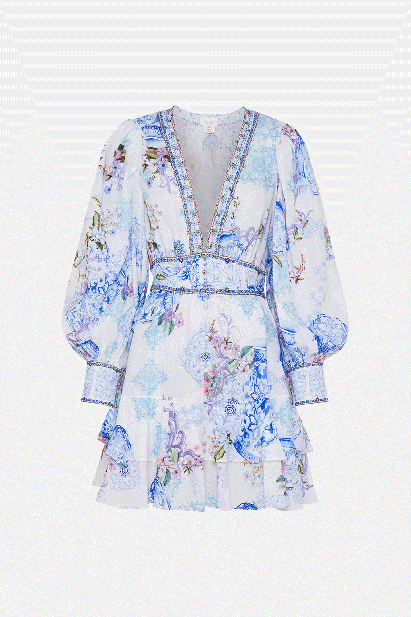 This luxury linen mini dress by Camilla features intricate Italian tile mosaics and delicate pastel florals, balanced with crystal embellishment. It will bring life to any occasion with voluminous blouson sleeves, a low cut v neckline, and dainty button details. The fitted waistband and two-tier skirt ensures a perfect fit, while still offering movement and a touch of drama.