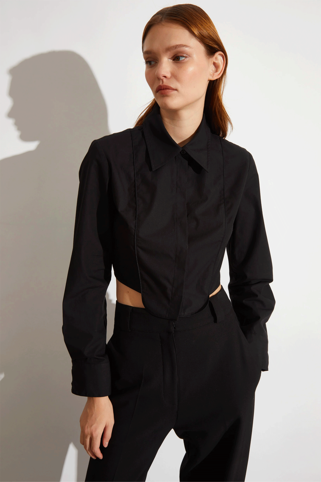 The Joyce Tuxedo Shirt from Saint Art is a stylishly menswear-inspired design with a flattering, feminine fit. Crafted from cropped poplin fabric, this shirt features black satin piping on the chest and a unique tuxedo bib detail. With a curved dipped hem, this luxe top will have heads turning.