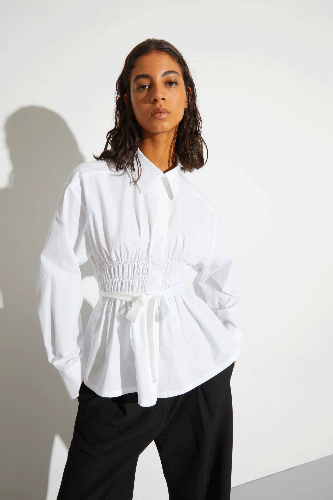 The Yvonne Ruched Front Tie Blouse from Saint Art is a fashionable and flattering piece. This unique button-down shirt is made from lightweight poplin fabric with ruched detailing and side slits for an adjustable fit. The streetwear inspired design gives you a tailored look with a feminine twist.